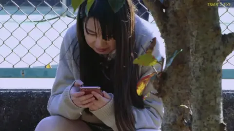 Asian Teen in School Uniform by Fence