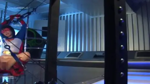 Asian in Superman Costume Industrial Fetish Scene