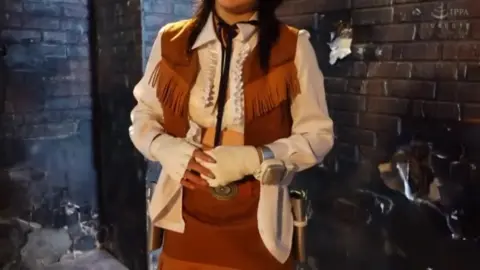 Asian Woman in Dimly Lit Brick Room