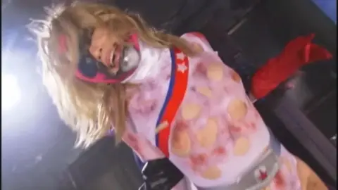 Asian Blonde in Fetish Outfit Performs Solo
