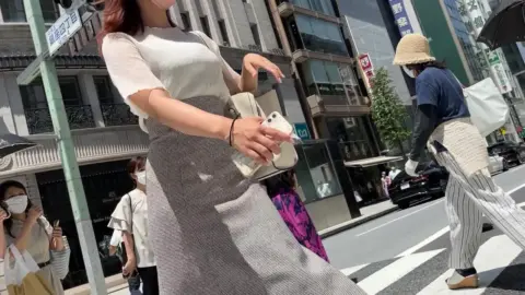 Asian Woman Walking on City Street