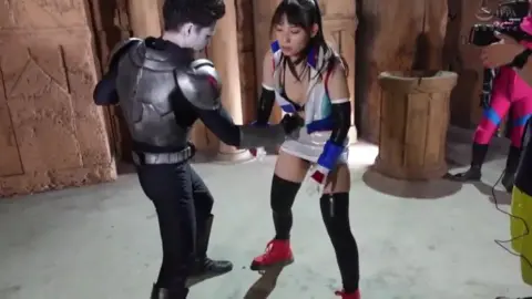 Asian Performers in Costumes Interacting