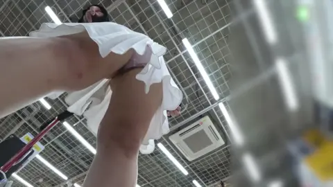 Slim Caucasian Woman Lifting Skirt in Store