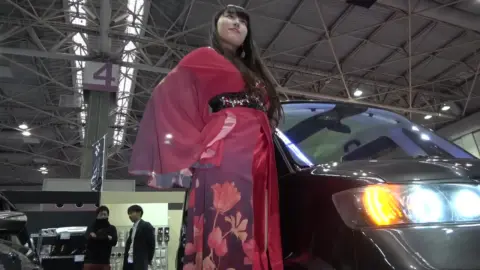 Woman with Fan by Car