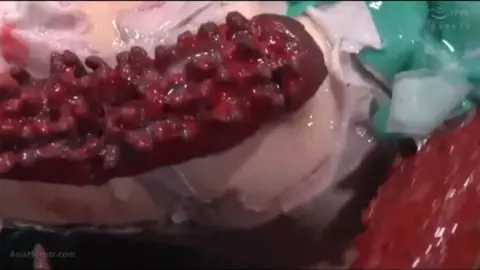 Asian teen in green dress with tentacle props