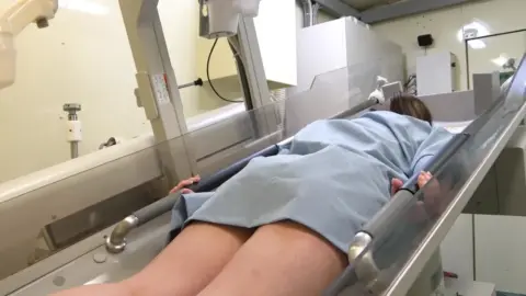 Brunette in Hospital Gown on Medical Table