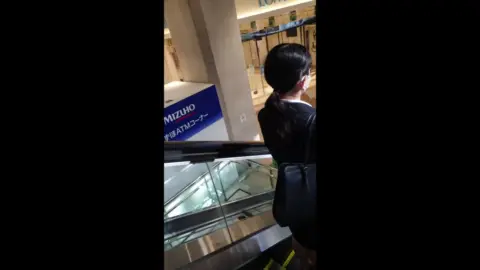 Asian woman in black dress at shopping mall