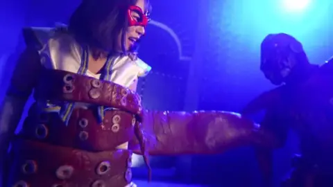 Asian Women in Red Masks and White Costumes