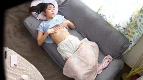 Asian teen relaxes on couch in lingerie