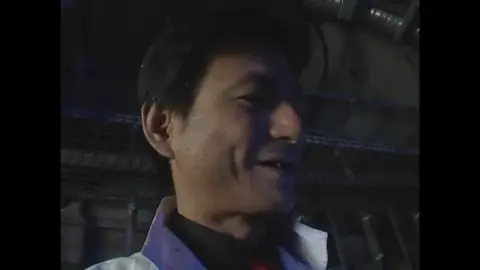 Asian Performers in Costumes and Industrial Setting