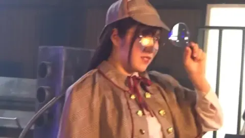 Asian woman in costume plays with props