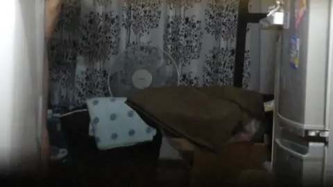 Asian girl posing with phone in dimly lit bedroom