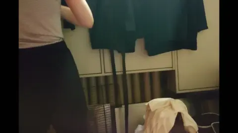 Slim Caucasian Woman Changing Clothes in Dim Bedroom