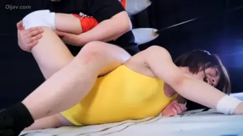 Wrestling Match Between Asian Man and Woman in Leotards