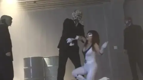 Asian Redhead in Mask and Costume Performs