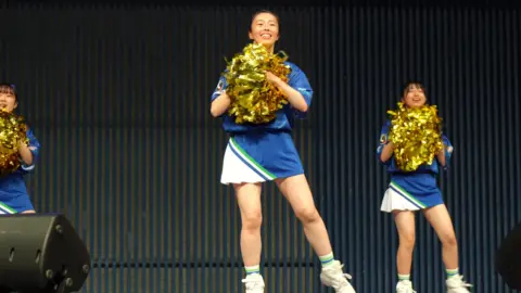 Asian Girls Dancing with Pompoms on Stage