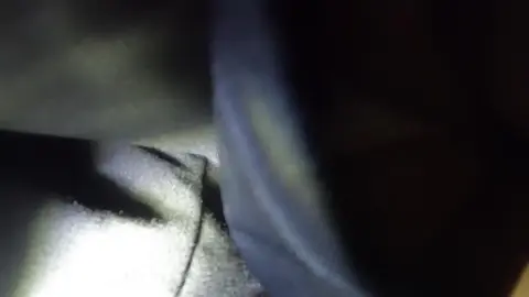 Man Adjusts Clothing in Dark POV