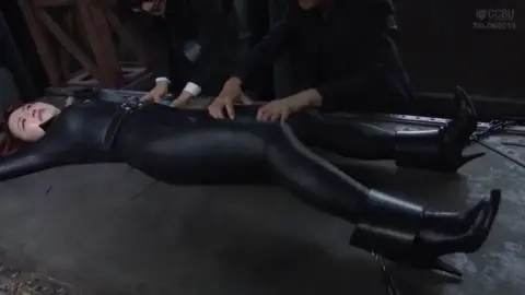 Redhead in Leather Restraint Scene