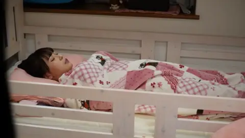 Busty Brunette Exposing Midriff on Bunk Bed