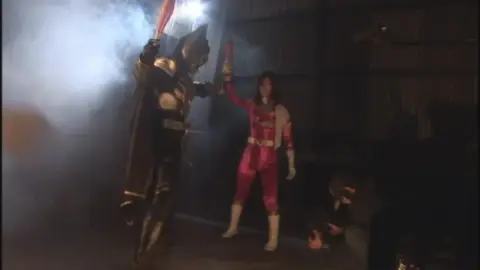 Asian Women in Pink Costumes with Muscular Man