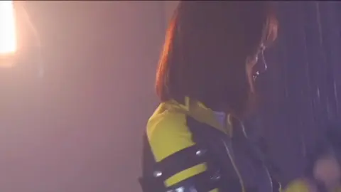 Red-Haired Asian Woman in Futuristic Jacket