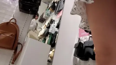 Slender Woman Shopping in Clothing Store