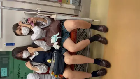 Asian Teens Take Selfies on Train