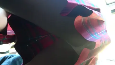 Slim Girl in Red Plaid Skirt Exposes Belly