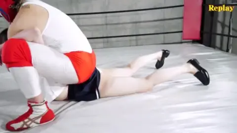 Wrestling Females in Red and White Outfits