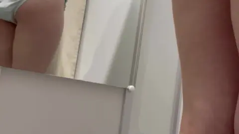 Asian Redhead with Pigtails and Face Mask in Bathroom