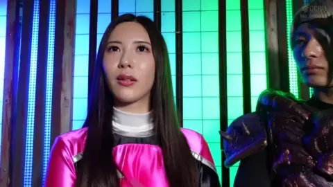 Asian Couple in Elaborate Costumes Pose in Neon Studio