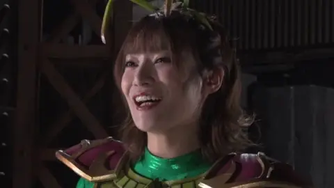 Asian Women in Costumes and Masks in Industrial Setting