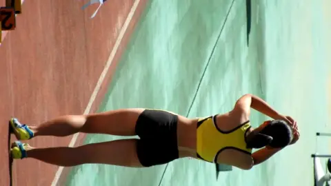 Asian Athletes Stretching and Pole Vaulting in Athletic Wear