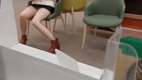 Asian Girl in Mask Reads in Library