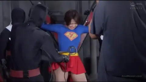 Asian woman restrained in industrial setting