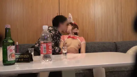 Asian Couple Intimacy in Dimly Lit Bar