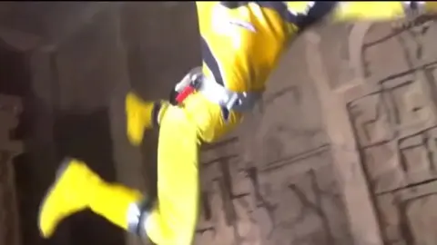 Men in Yellow and White Suits Engage in Playful Kicking