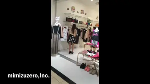 Asian girl tries on clothes in store
