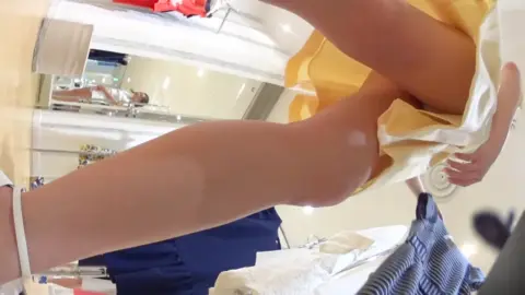 Asian Girl Tries On Clothes in Store