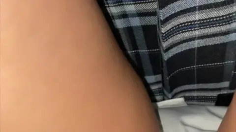 Asian teen in plaid skirt and uniform