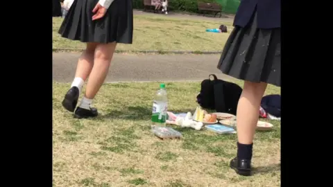 Asian Teens in School Uniforms Eating in Park