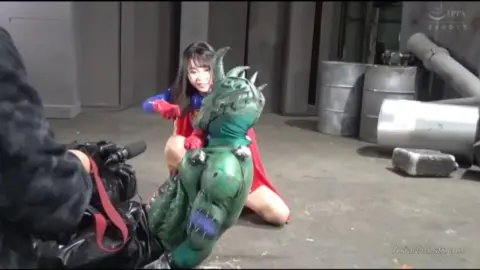 Asian Girl in Industrial Setting with Green Costumed Man