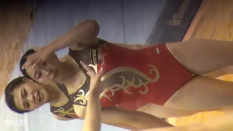 Asian Teens Embrace in Gym