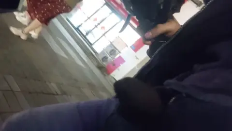 Asian girl in red skirt walks down street