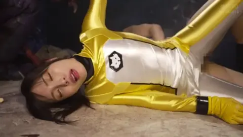 Asian woman in yellow costume in erotic bondage and domination scenes