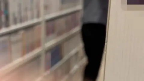 Asian Men Browse Books in Library