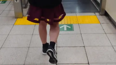 Asian girl in red skirt on subway