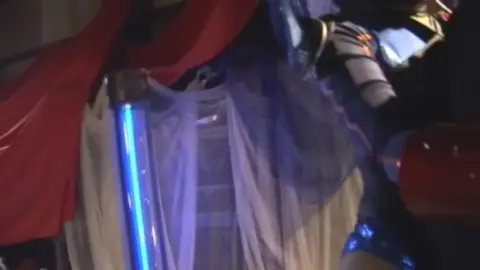 Woman Posing Suggestively with Assistants