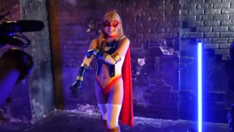 Blonde in Superhero Costume and Business Attire Erotica