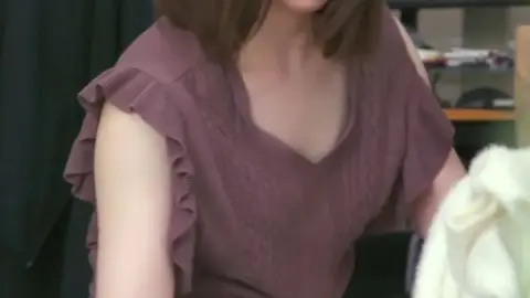 Asian Brunette in Cluttered Room